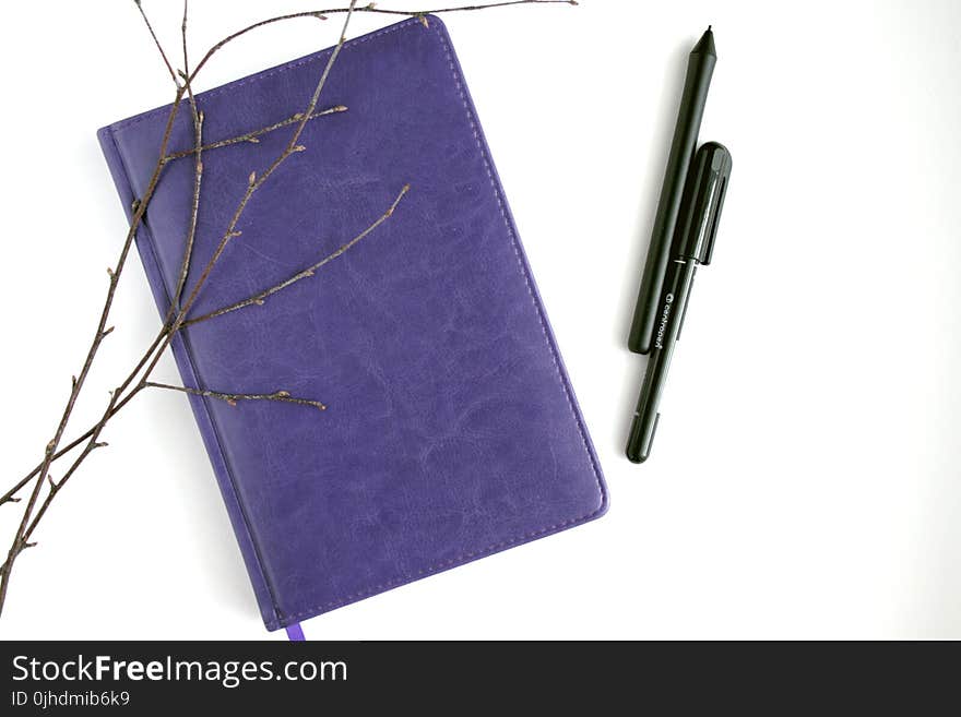 Purple Leather Notebook, Black Pen, and Brown Branches