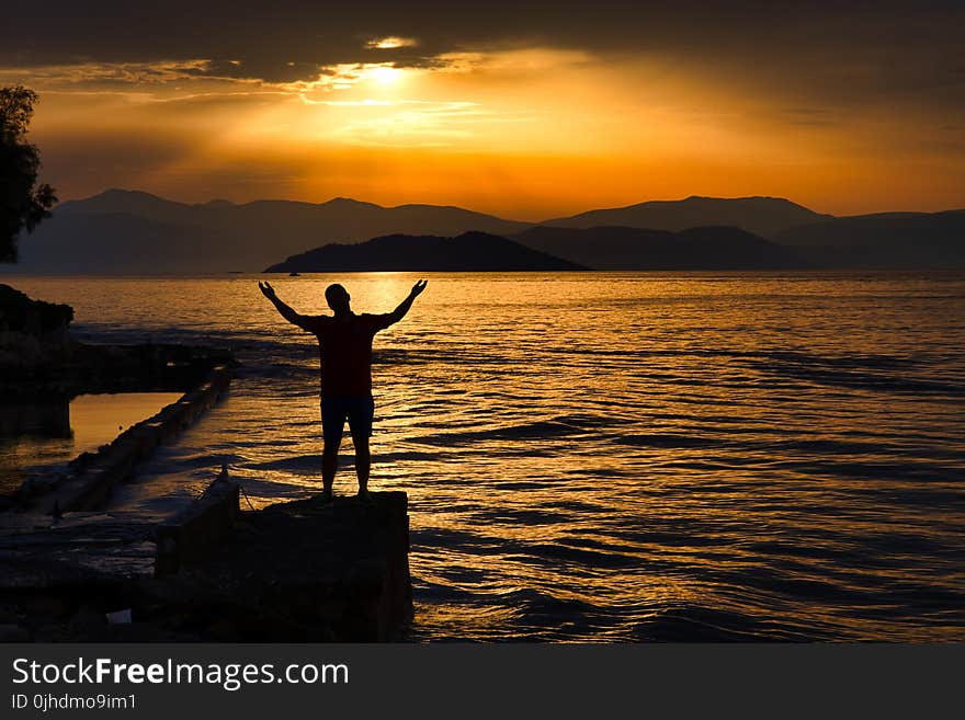 Silhouette Photo of Person Standing Near Beach