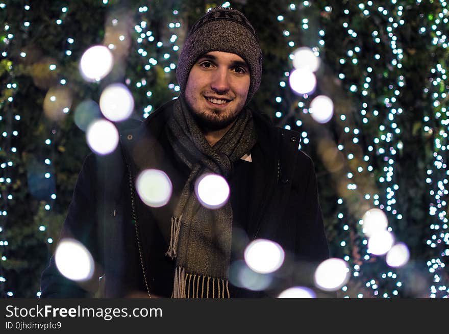 Man Wearing Snow Coat With Bokeh Light Background