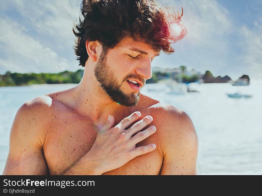 Topless Man in Front of Body of Water