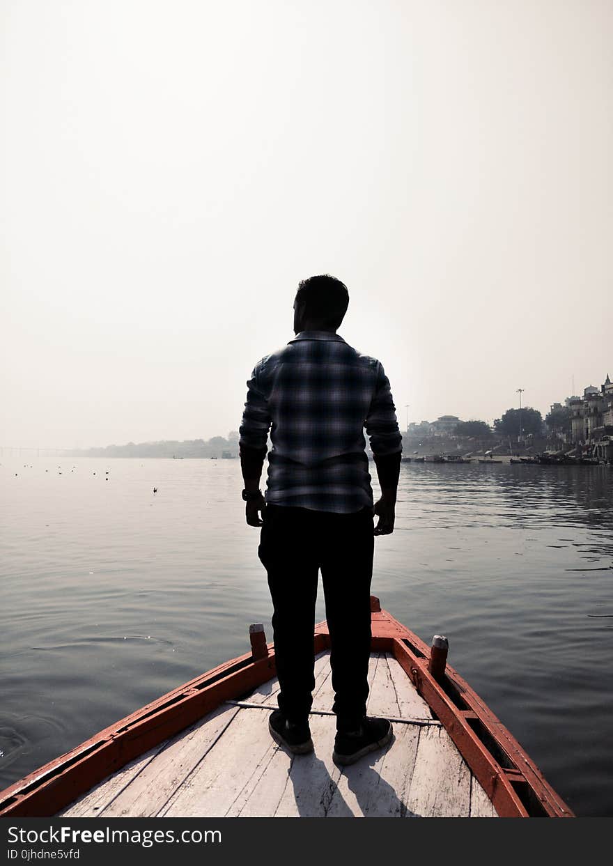 Man Standing On Wooden Boat