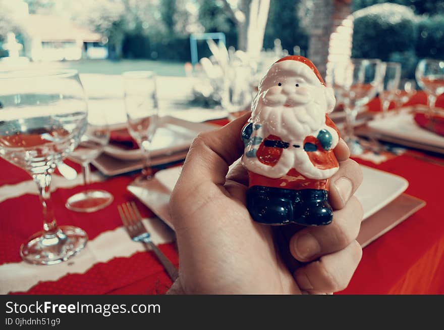 Person Holding Santa Claus Figurine