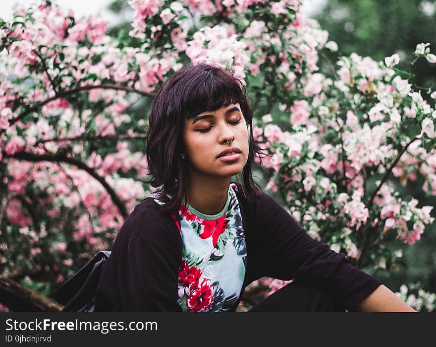 Woman Wearing White and Red Floral Crew-neck Shirt Near Pink Petaled Plant