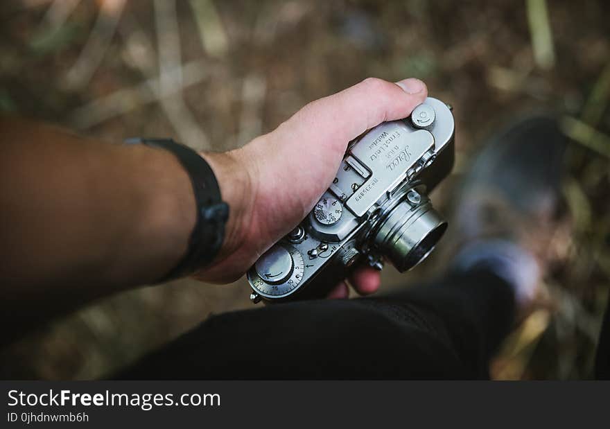 Person Holding Grey Point-and-shoot Camera