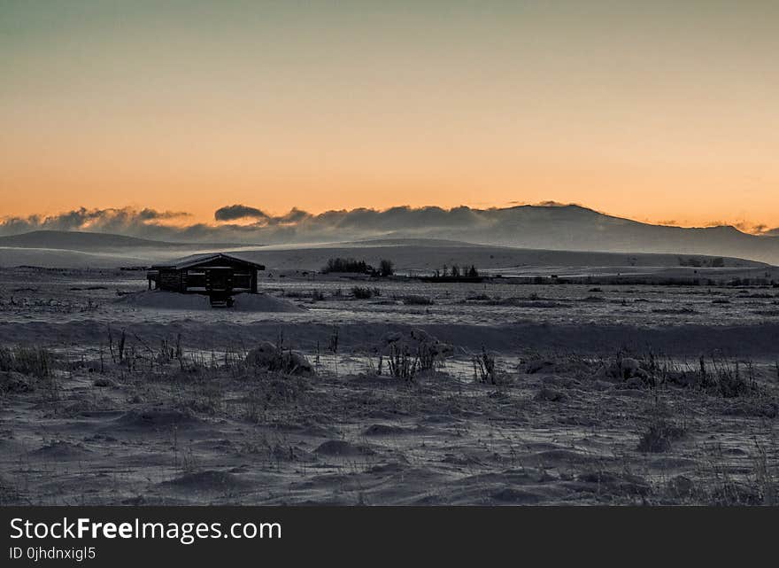 Grayscale Photo of Wooden Cabin in the Middle of Desert