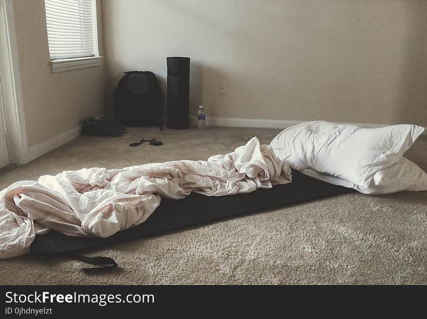 Two White Rectangular Pillows With White Blanket on Floor