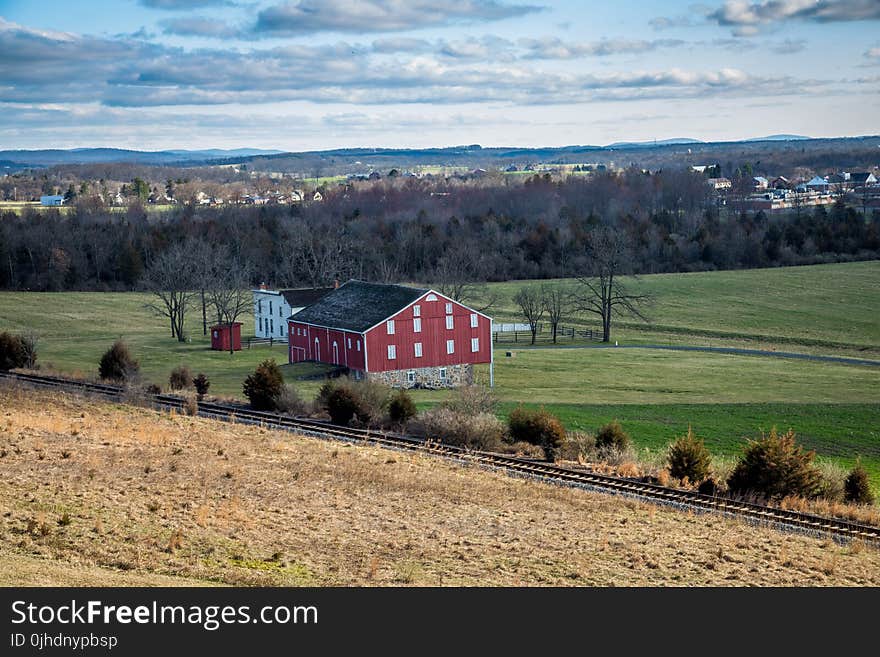 Red And Grey House In The Middle Of Green Grass Field