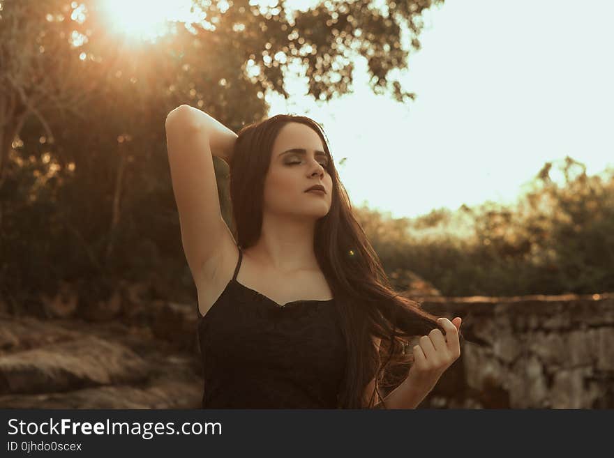 Woman Holding Her Hair Standing Near Tree