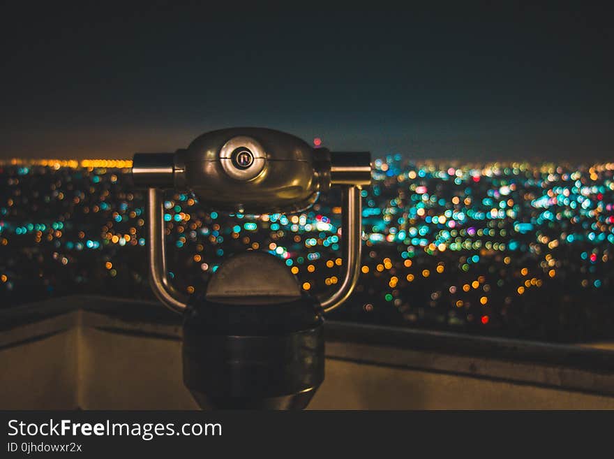 Black Binocular Facing Lighted City at Nighttime