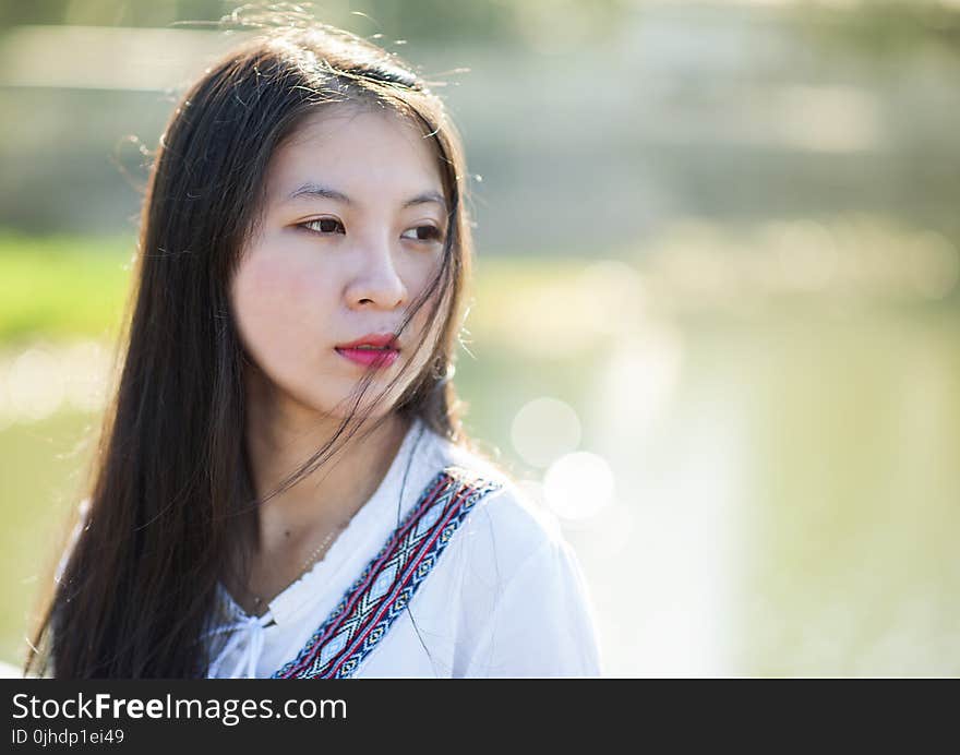 Woman in White, Blue, and Maroon Top Facing Right