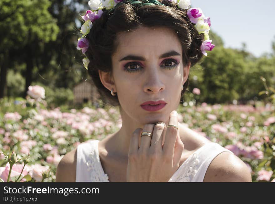 Woman in White Floral Headdress and White Sleeveless Top Behind Pink Flower Field at Daytime