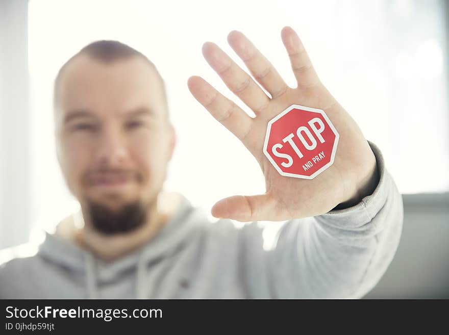 Photography of a Persons Hand With Stop Signage