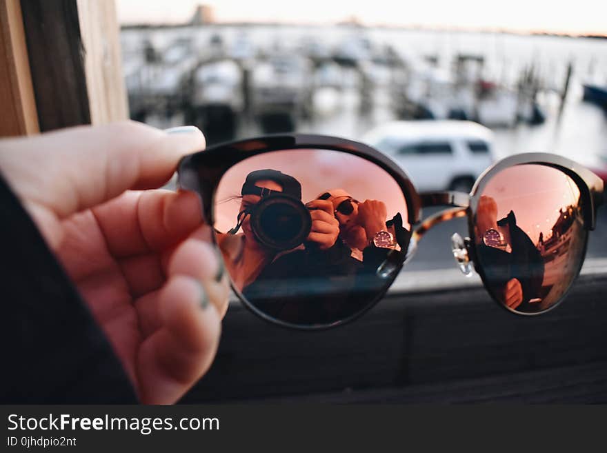 Close-Up Photography of a Person Holding Sunglasses