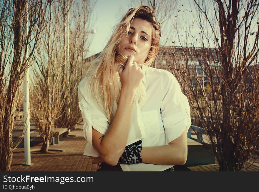 Blonde Woman in White Dress Shirt Beside Brown Plants