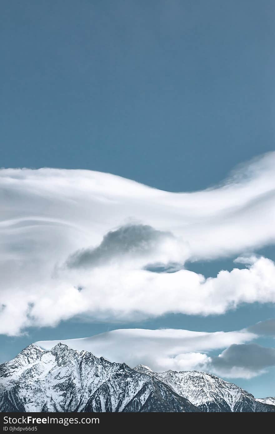 Cloud Formation Above Snow-capped Mountain