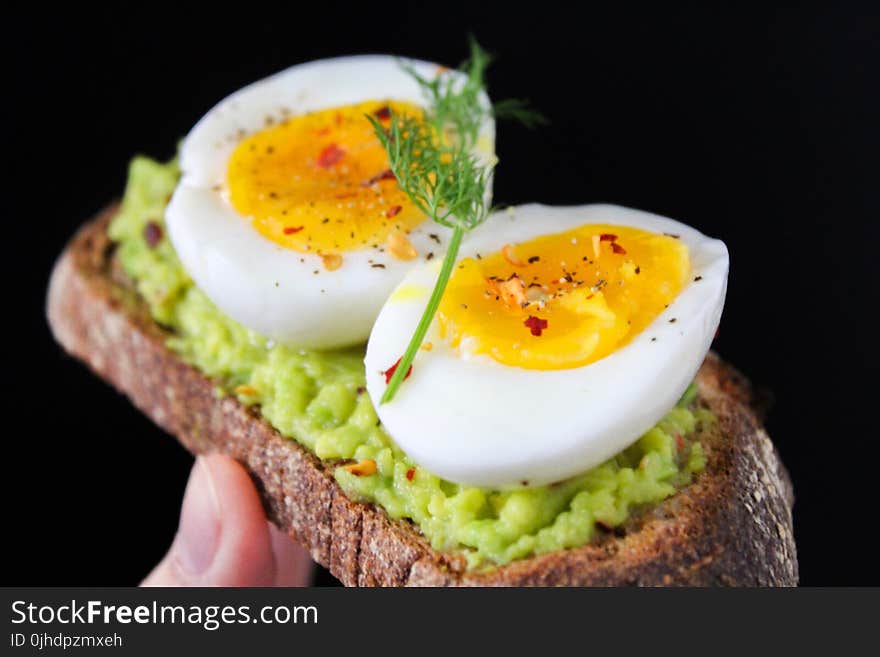 Sliced Egg on Top of Green Salad With Bread