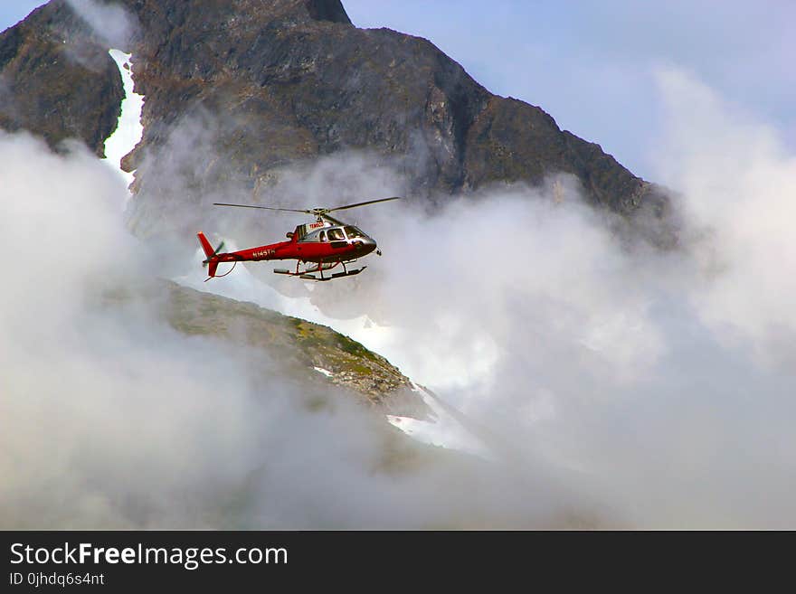 Red Helicopter on Top of Foggy Mountain