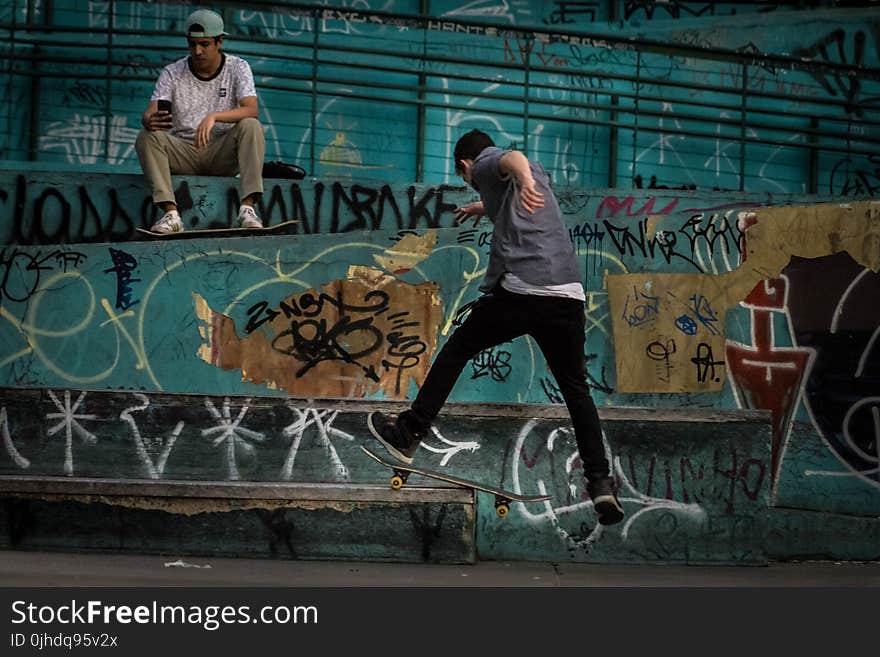 Man Wearing Geay Shirt Playing Skateboard