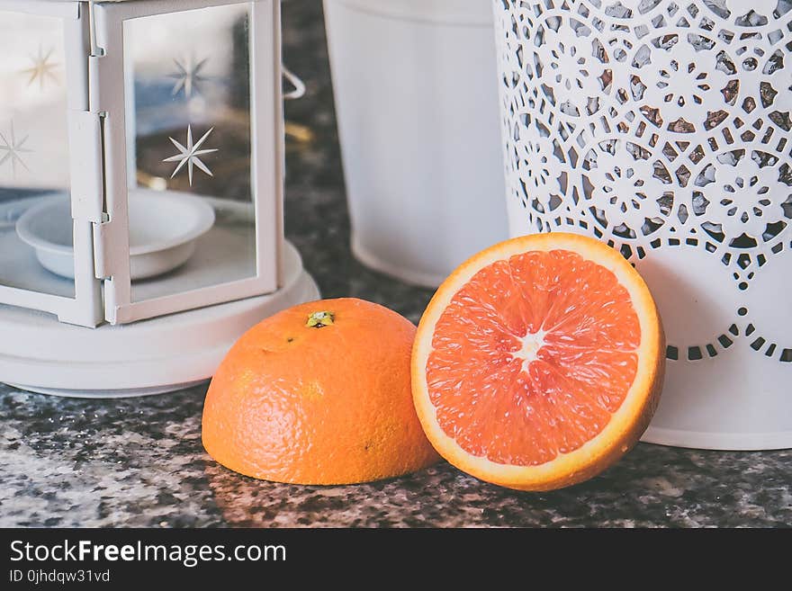 Sliced of Orange Fruit Near on White Framed Glass Candle Lantern