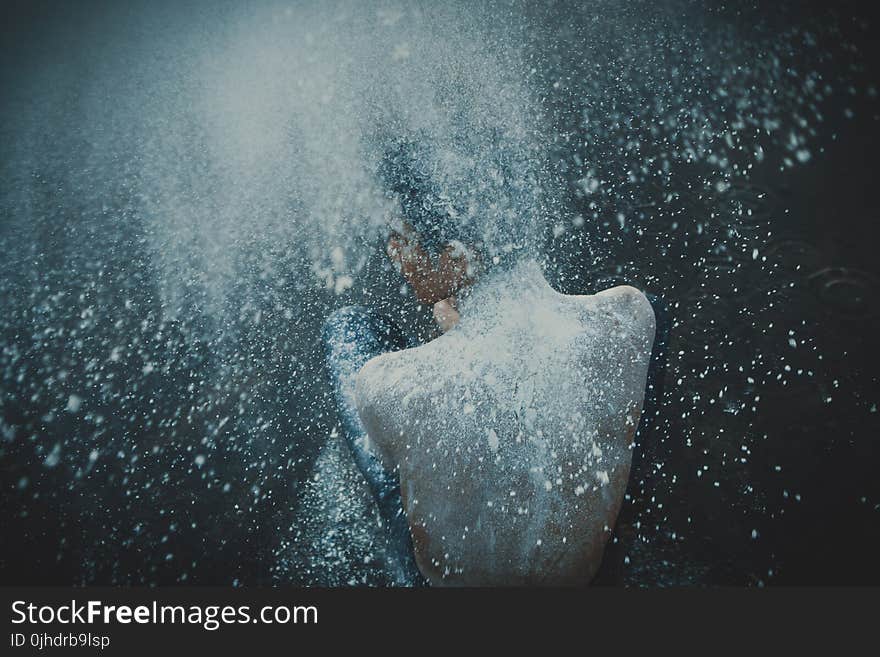 Topless Man Showering with White Powders