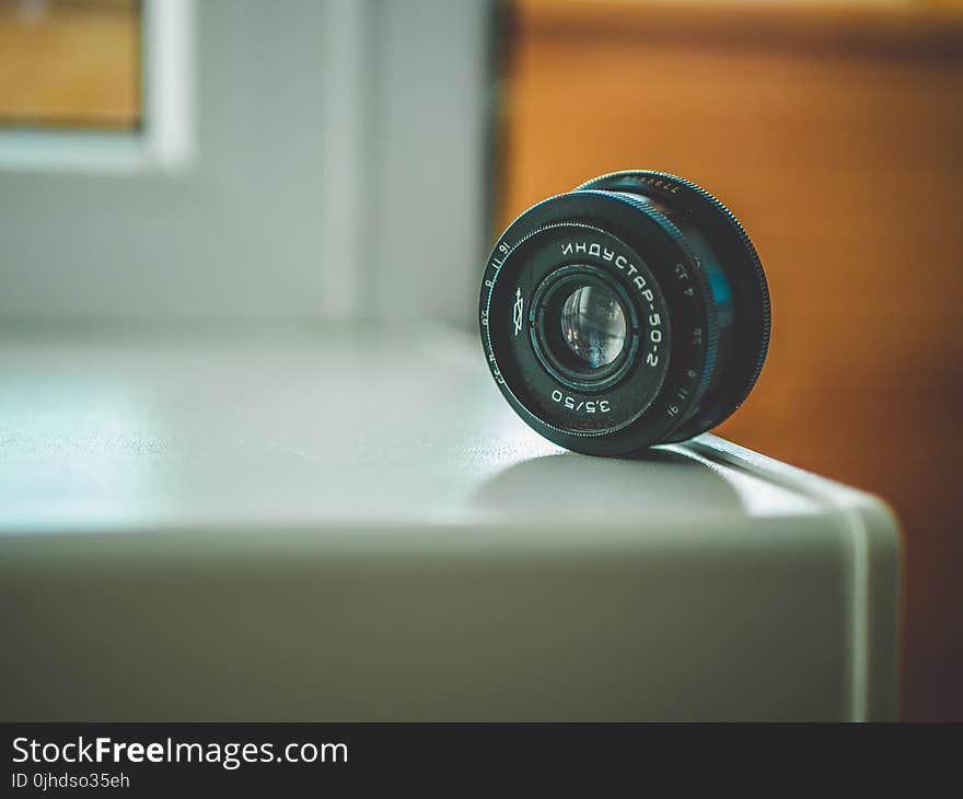 Selective Focus Photography of Black Telephoto Lens on White Table