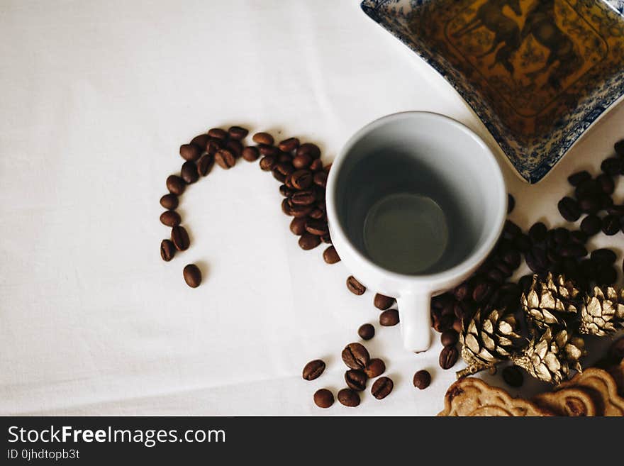 Brown Coffee Beans Near White Ceramic Mug