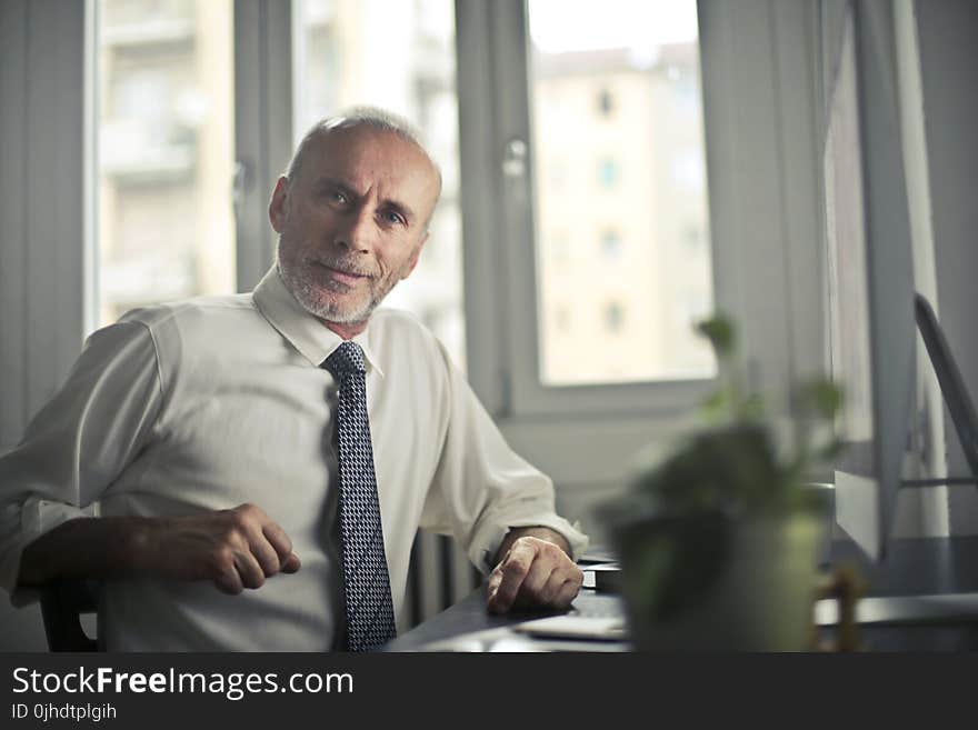 Man Sitting on Chair Beside Table