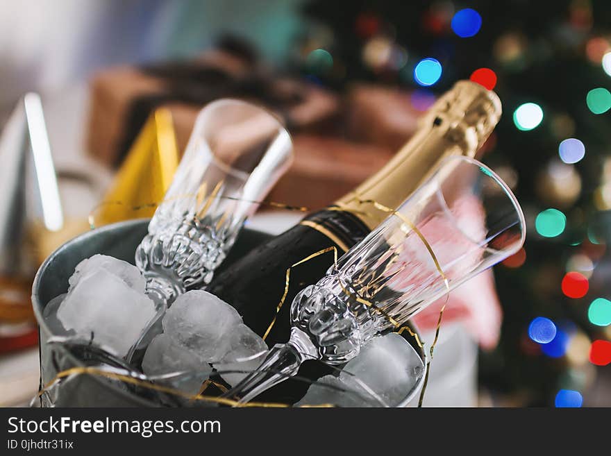 Selective Focus Photography of Brown Labeled Bottle and Two Clear Glass Champagne Flutes