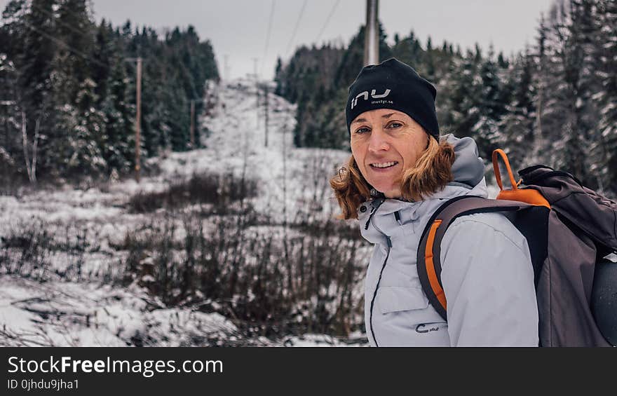 Photo of Woman Wearing Gray Windbreaker Jacket Carrying Backpack