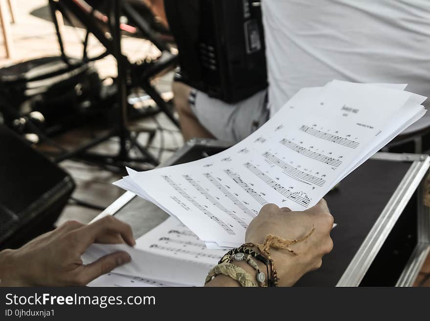 Person Holding White Musical Note Sheets