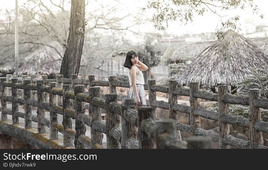 Woman Wearing White Sleeveless Dress Standing on Gray Wooden Dock