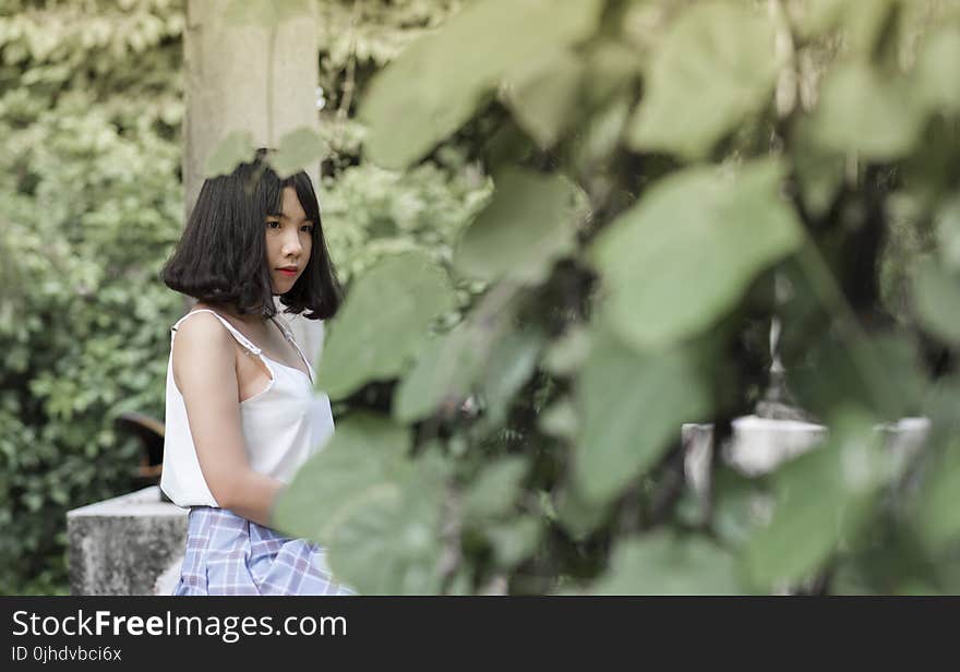 Woman Wearing White Spaghetti Strap Top Sitting in Garden