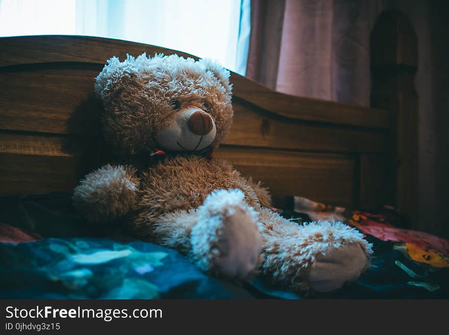 Brown Bear Leaning on Bed Headboard