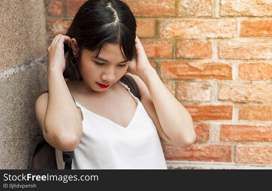 Woman Holding Her Hair While Standing on the Corner