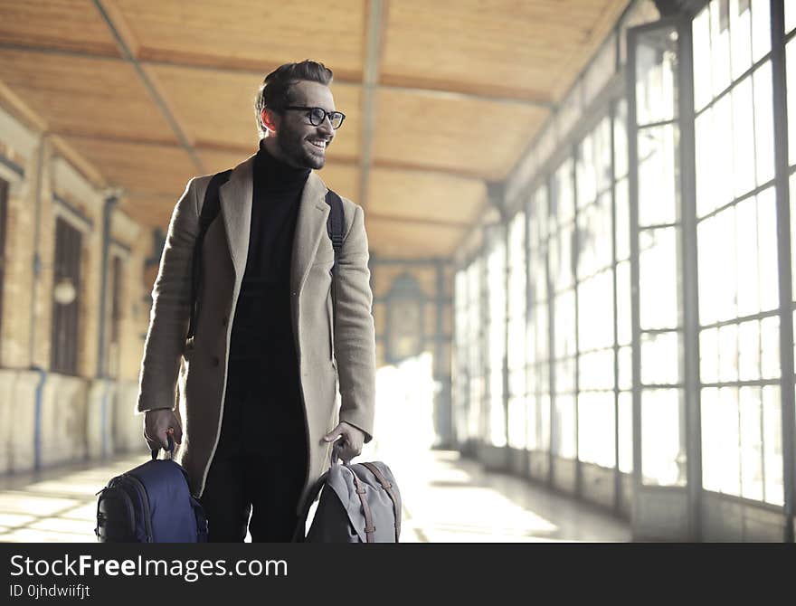 Man in Brown Robe Carrying Bag Smiling