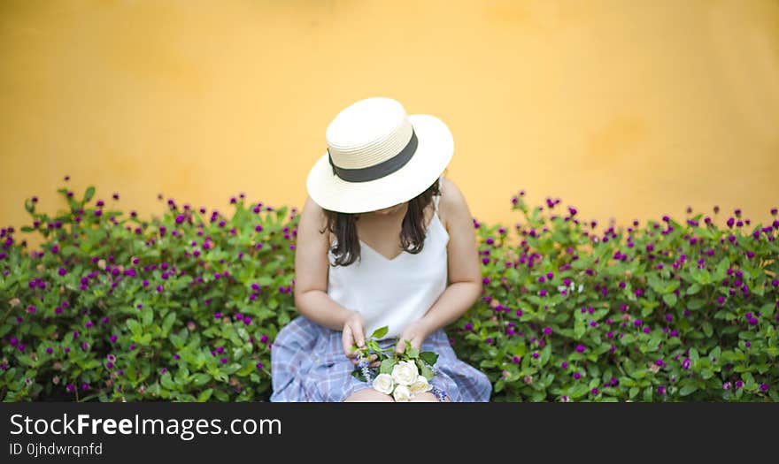 Woman Holding Bunch of White Roses While Sitting Near Flower Fields