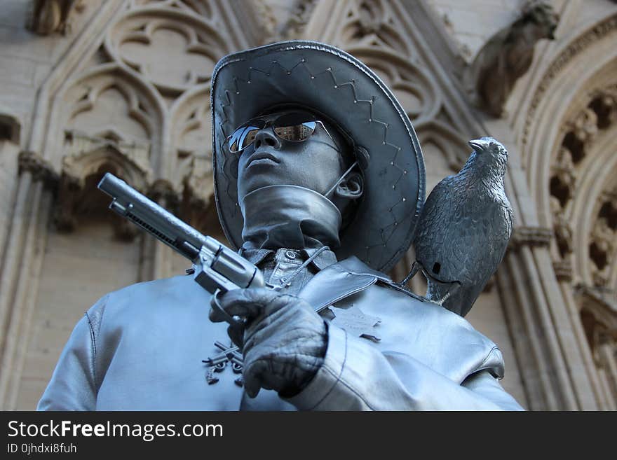 Selective Focus Photography of Cowboy Holding Revolver Pistol Statue