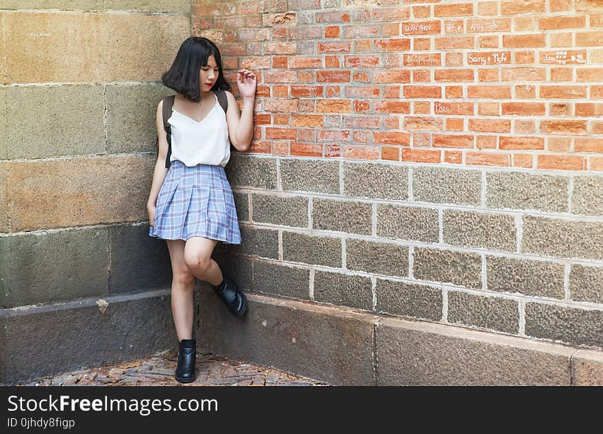 Woman Beside Brick and Cinder Wall