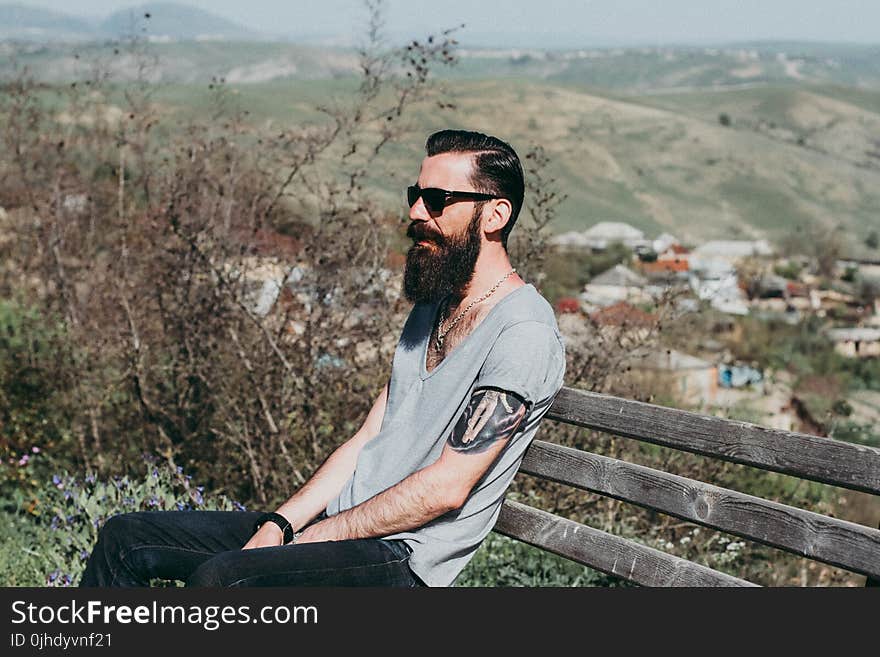 Photography of a Man Sitting on Wooden Bench