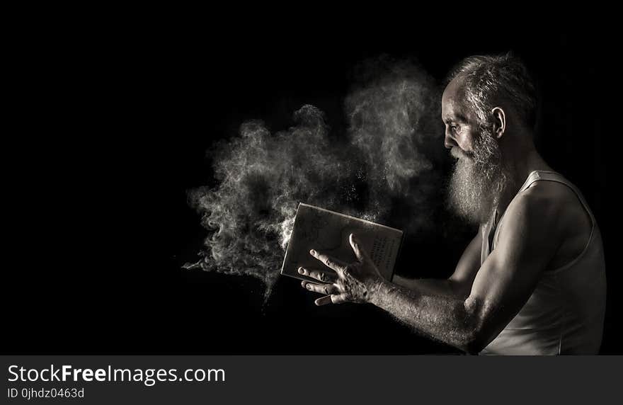 Man in White Tank Top Holding Book