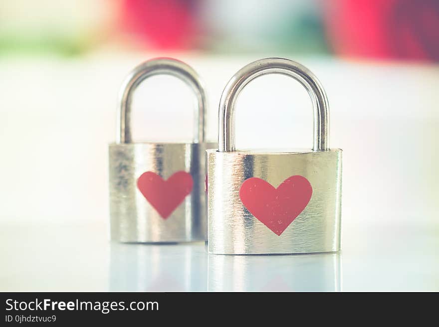 Bokeh Photo of Two Heart-printed Stainless Steel Padlocks