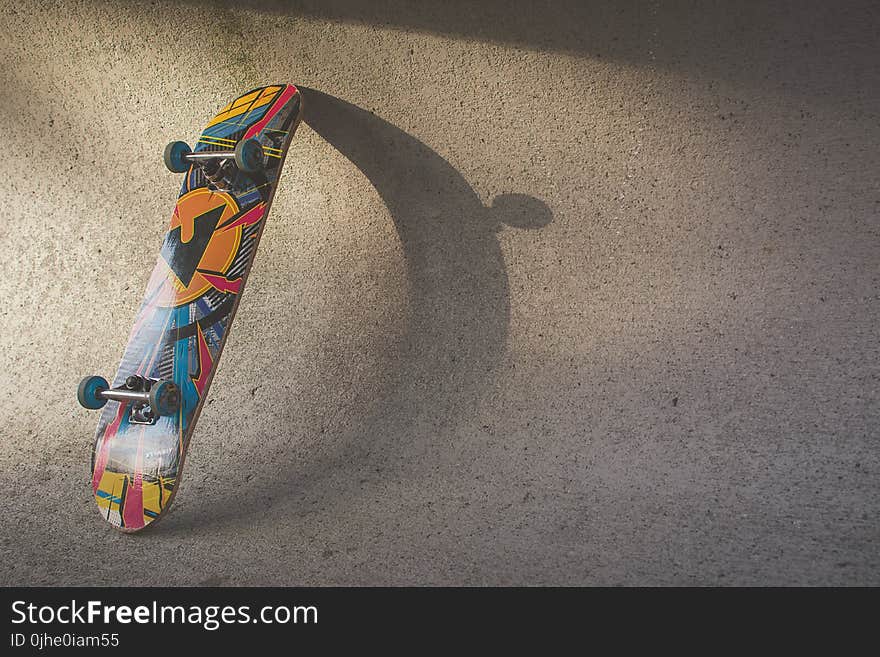 Multicolored Skateboard Leaning on Wall