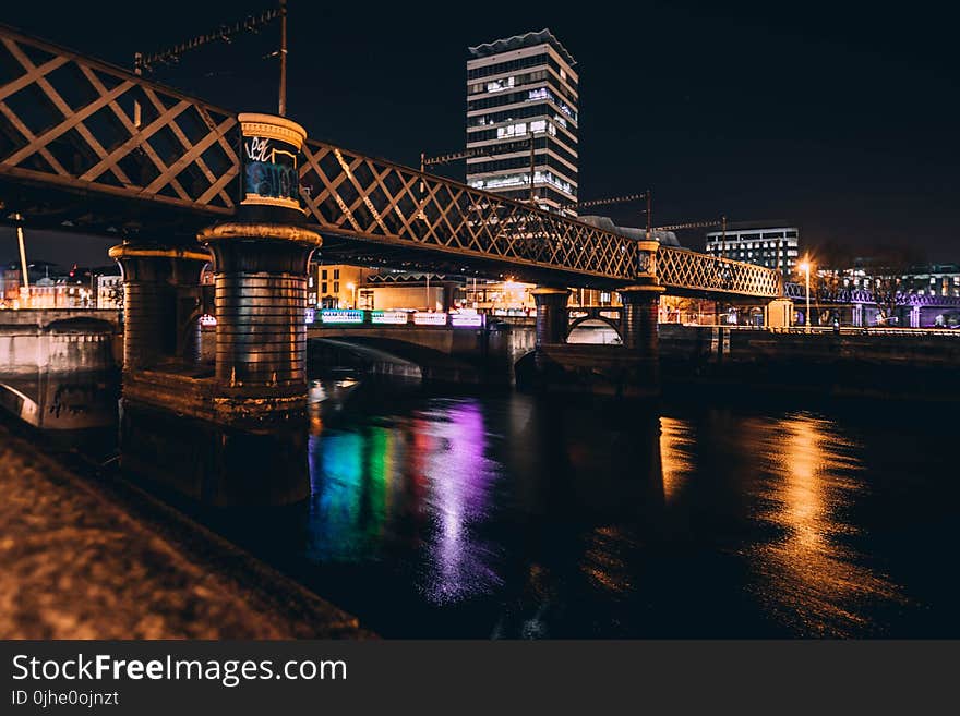 Architectural Photo of Brown Concrete Bridge and High Rise Building during Night Time