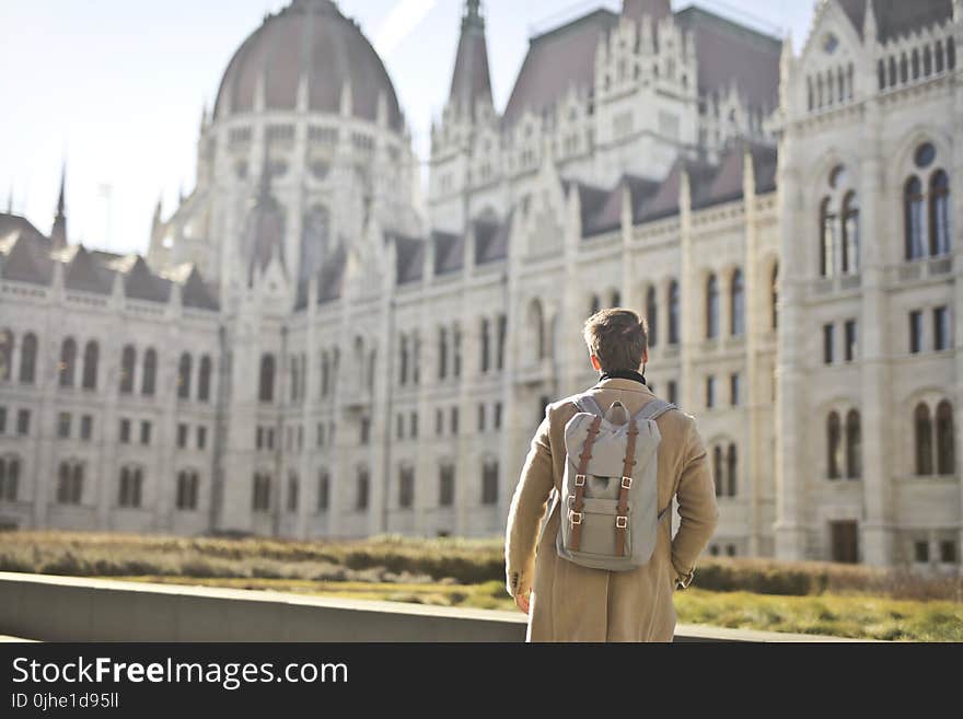 Focus Photography of Man Looking on White Concrete Building