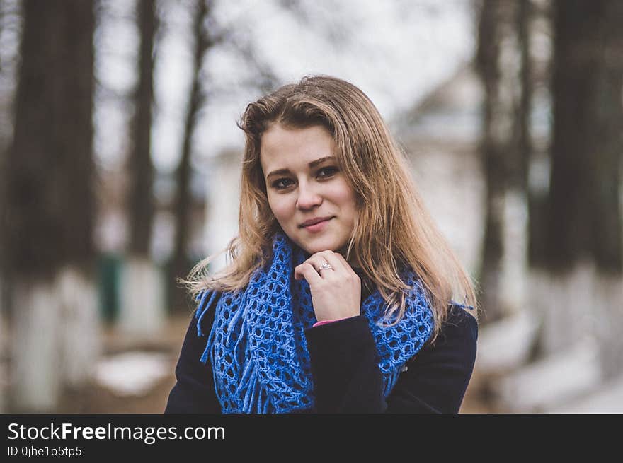 Selective Focal Photo of Woman Wearing Blue Knitted Mesh Infinity Scarf