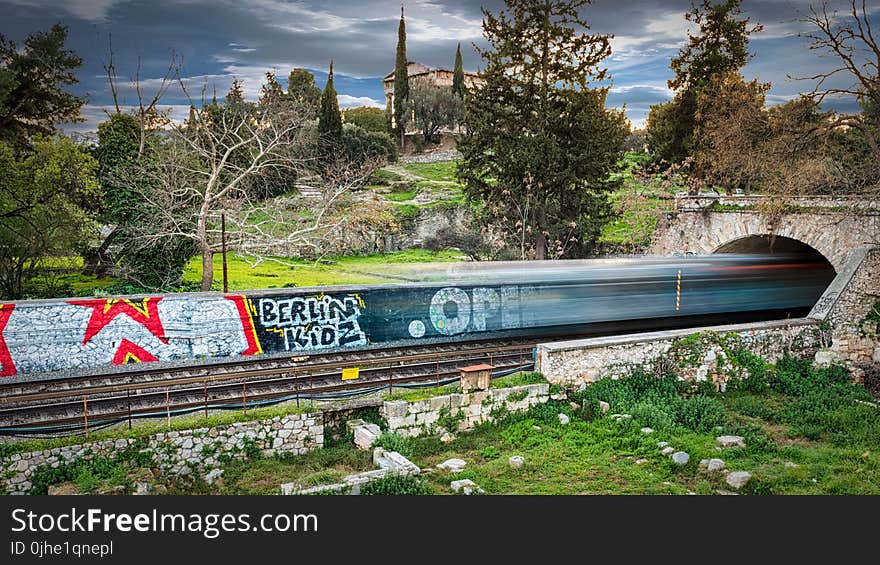 Time Lapse Photography of Train Passing Through Bridge