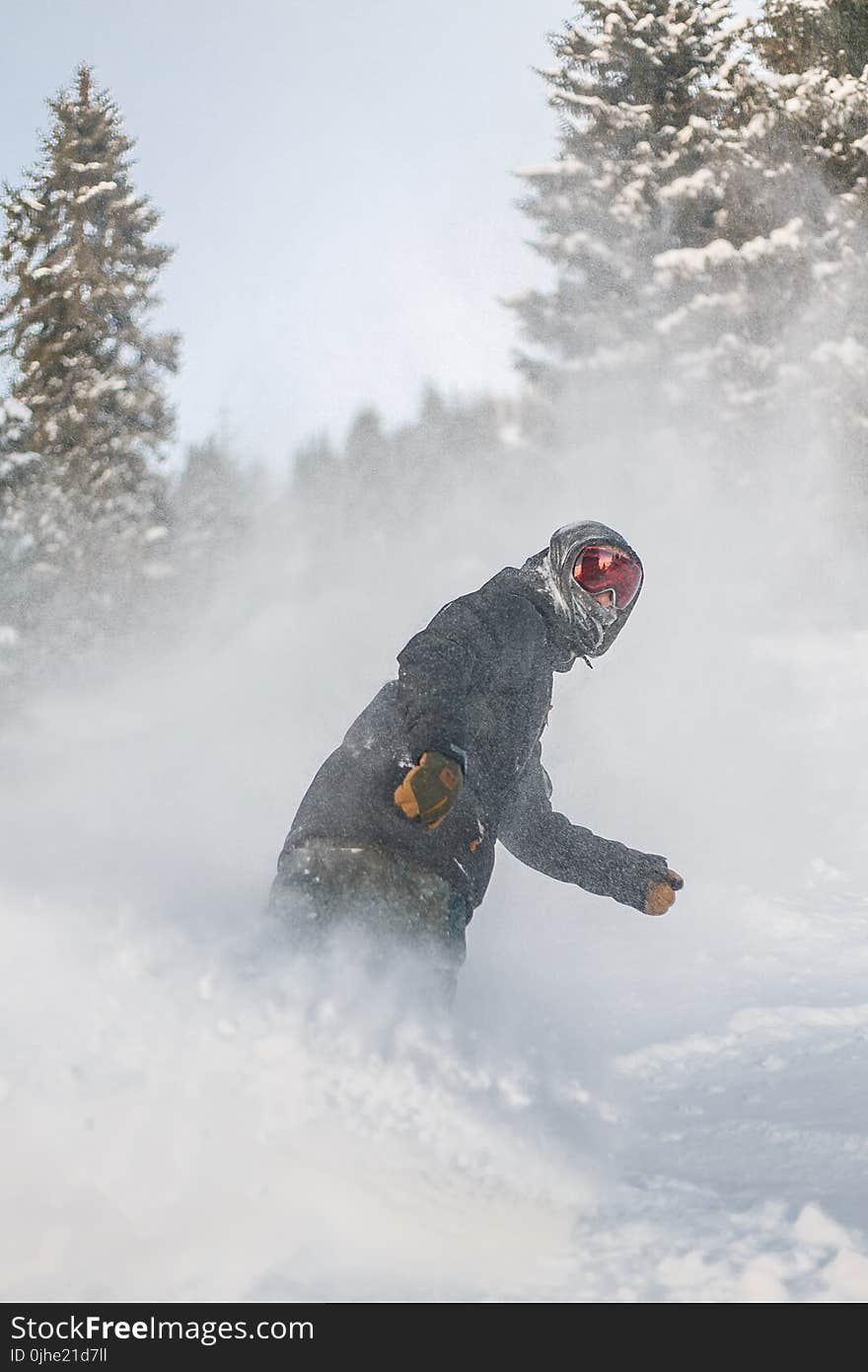 Person in Grey Jacket and Red Snow Goggles Riding on Snowboard