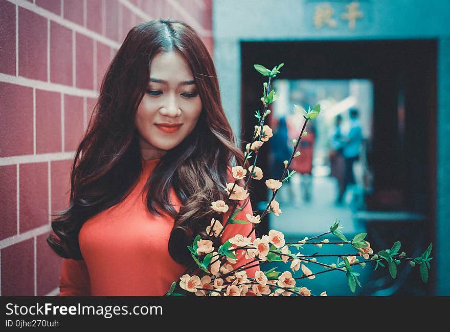 Woman Wearing Red Long-sleeved Shirt in Front of Flower