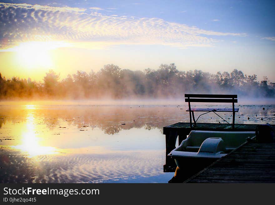 White Plastic Boat on Lake Beside Wooden Dock during Golden Hour