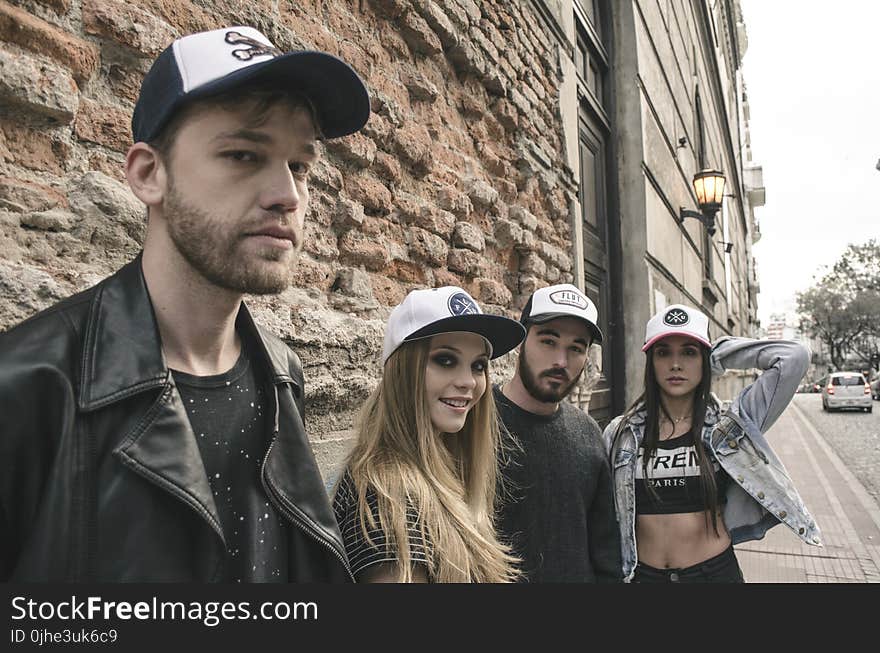 Group of People Wearing Fitted Caps Beside Road